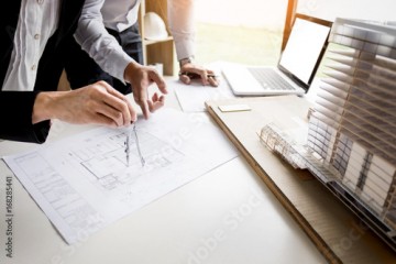  Person's engineer Hand Drawing Plan On Blue Print with architect equipment