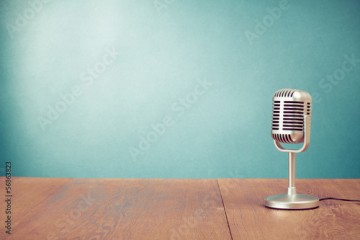 Retro style microphone on table in front aquamarine wall