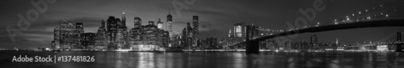 New York city with Brooklyn Bridge, iconic skyline panorama at night in black and white