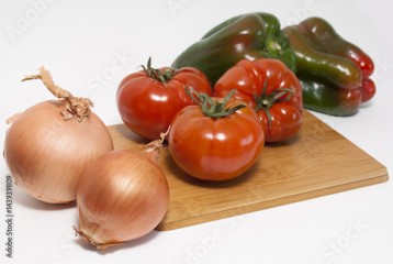 Vegetables (tomatoes, pepers, onios) on the wooden board