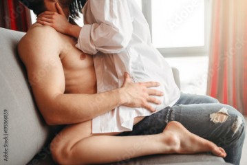 Sexy woman sitting on man, intimate games on couch