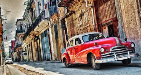 old american car parked with havana building in background