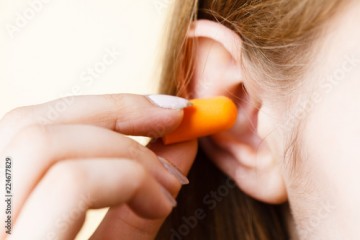Woman putting earplugs
