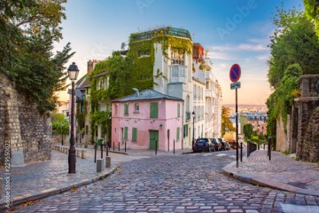 Cozy old street with pink house at the sunny sunrise, quarter Montmartre in Paris, France