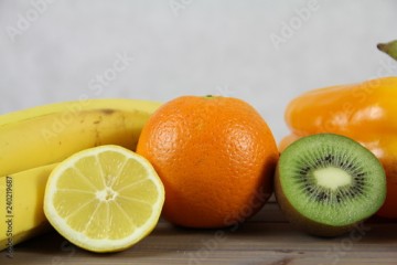 Zdrowa dieta - owoce i warzywa - pomarańcze, kwi, cytryna i banan na drewnianej skrzynce