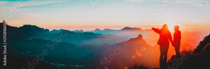 mother and son travel in mountains at sunset, panorama