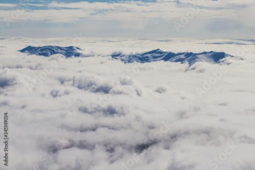Gray sea from the clouds from which peaks peep