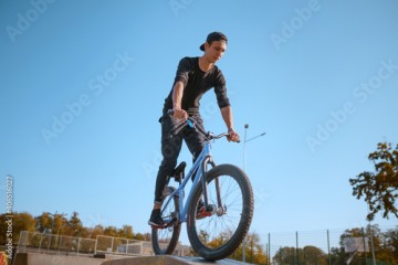 Male bmx biker, jump in action, skatepark
