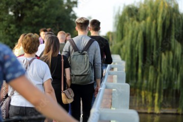 Para młodych ludzie, kobieta i mężczyzna z plecakami spaceruje po moście we Wrocławiu. 