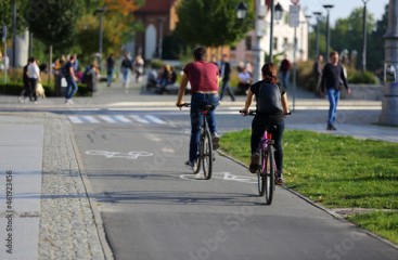 Kobieta i mężczyzna jadą rowerami ścieżką rowerową w mieście, Wrocław.
