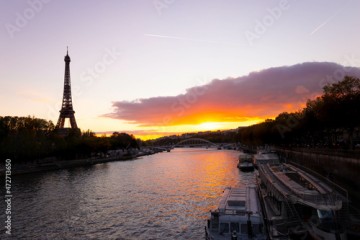 Eiffel tower in Paris at sundown: romantic and perfect for Valentine's day. Bateau mouche