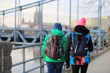 Dwie kobiety z plecakami idą mostem Grunwaldzkim we Wrocławiu.