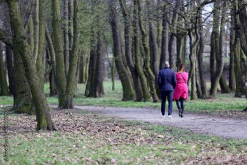 Para ludzi spaceruje ścieżką w parku.