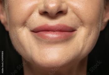 Close-up middle age woman's lower face with first wrinkles. Female model with well-kept skin. Concept of women's health and beauty, cosmetology, Anti-aging care