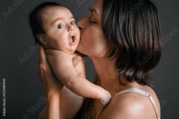 Mom, mummy, young mother with little baby daughter. Breast-feeding. Mum kissing,hugging child. Newborn cute happy girl smiling in woman hands. Family happiness. Age parents, parenting, motherhood