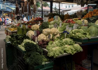 Stragan z warzywami na placu targowym. Sałata, kalafior, brokuł, marchew.