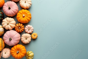 Small orange, white and pink pumpkins on pastel blue background