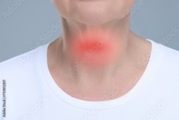 Endocrine system. Woman suffering from pain in thyroid gland on grey background, closeup