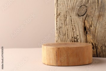 Presentation for product. Wooden podium on beige background. Space for text