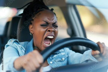 Furious African American woman. Emotional woman feeling extremely furious while driving near crazy dangerous driver