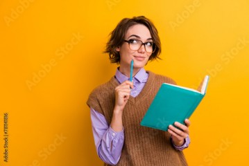 Photo of smart girl dressed knitwear waistcoat hold copybook look at promo empty space write plan isolated on yellow color background