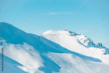 View of Kasprowy Wierch on a sunny and wintry day. Many people at the summit. Tatra National Park, Poland.