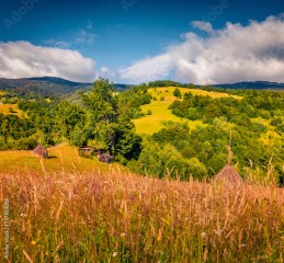 Wonderful morning scene of Rogojel village with haycocks. Bright summer view of Cluj County, Romania, Europe. Beauty of countryside concept background..
