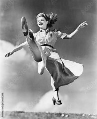 Woman in a flowing dress leaping through the air 