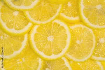 Fresh lemons background. Yellow food background. Juicy slices of lemon. Top view