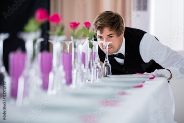 Waiter Looking At Table Arrangement