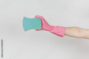 Close up of female hand in pink gloves horizontal holds blue large sponge for cleaning and washing dishes isolated on white background. Cleaning supplies concept. Copy space for advertisement