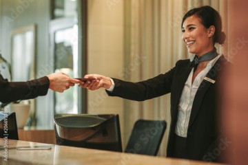 Smiling receptionist attending hotel guest