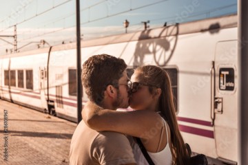 Young couple kiss passionately to say goodbye before their trip.