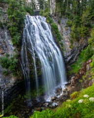 Large waterfall cascading down in the mountains. Mount Rainier National Park