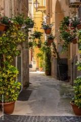 ukwiecona wąska uliczka w starym miasteczku na południu Włoch