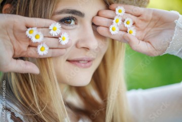A woman holds flowers near her face in her hands. High quality photo