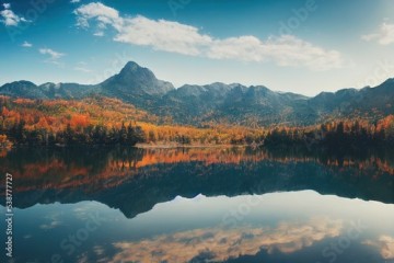 Autumn panorama of a forest lake in the mountains. Mountain lake in autumn. Lake in autumn mountain forest. Panorama on autumn mountain lake