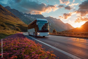 Intercity bus on mountainous highway with picturesque sunset and blooming flowers, ideal for scenic travel and adventure tours.