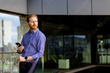 Professional Gentleman Engages in a Serious Conversation on His Smartphone at During a Sunny Afternoon